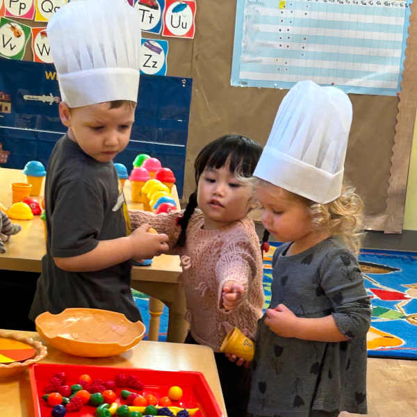 Kids holding up gloved hands